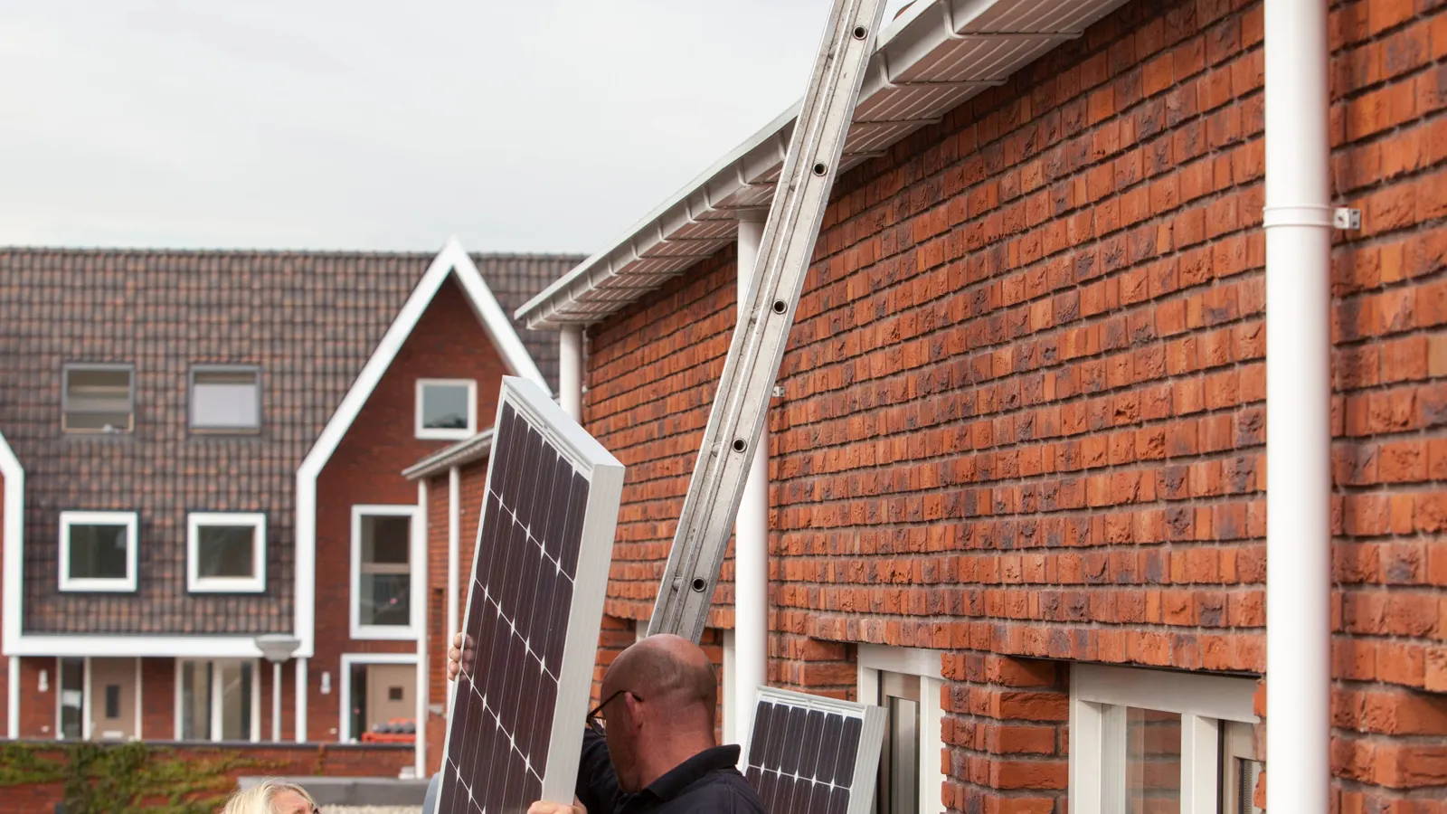 Installateurs leggen zonnepanelen op een dak in Vleuten
